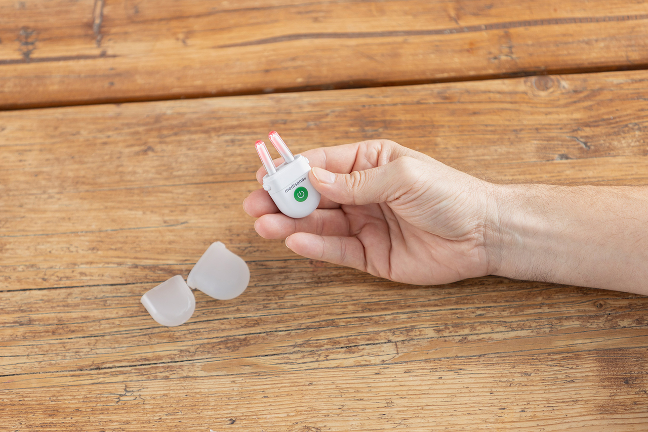 Hand hält das medisana medinose compact Nasentherapiegerät mit Schutzkappe – kompaktes Gerät zur Linderung von Allergiesymptomen durch Lichttherapie